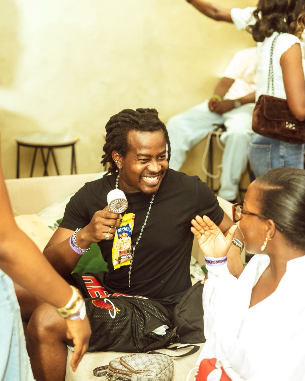 A man laughing with a mic in hand among the crowd at a past hangout